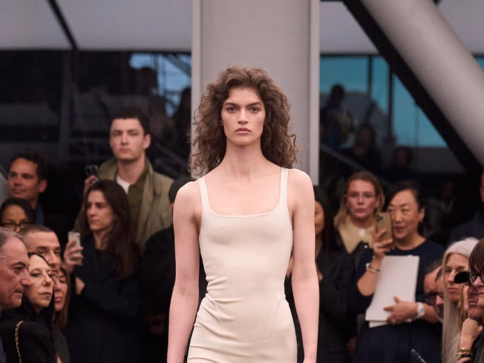 Pieter Mulier Alaïa 2026, Alaïa final collection, swan song Versace move, Azzedine Alaïa legacy, precision silhouettes Alaïa, restrained elegance fashion, Summer-Fall 2026 review, WWD runway review, form-hugging velvet suits, ruffled skirts Alaïa, real luxury definition, team portraits tribute, techno soundtrack fashion, iteration in design, connoisseur appeal, Mulier Versace transition, body architecture Alaïa, emotional storytelling couture, pitch-perfect finale, house codes evolution