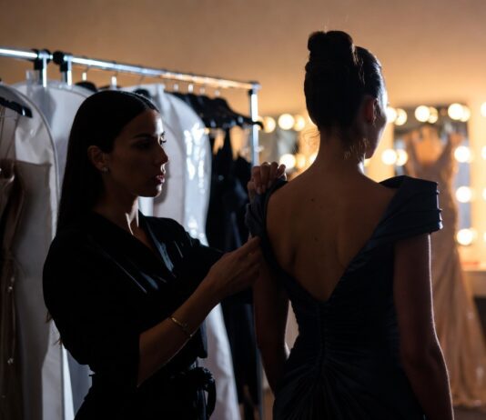 The Stylists Behind the Biggest Red Carpet Moments A red carpet stylist making final adjustments to a custom gown backstage representing Runway Magazine's complete guide to the stylists behind the biggest red carpet fashion moments