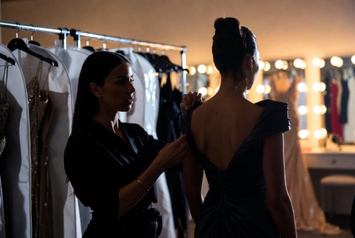 The Stylists Behind the Biggest Red Carpet Moments — Runway Magazine A red carpet stylist making final adjustments to a custom gown backstage representing Runway Magazine's complete guide to the stylists behind the biggest red carpet fashion moments
