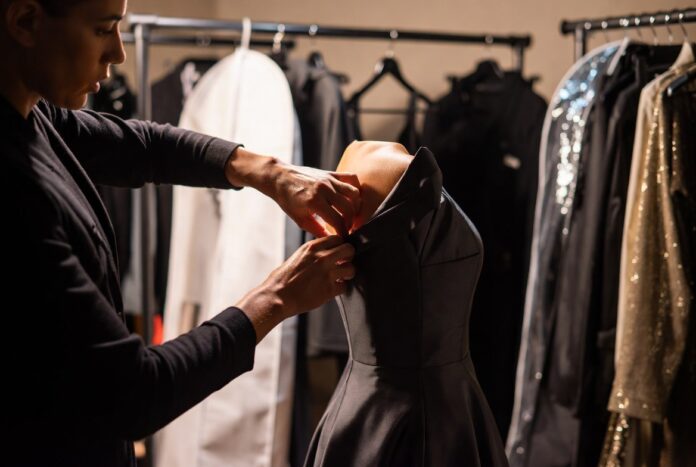Celebrity Fashion Stylists: The Hidden Power Players — Runway Magazine A celebrity fashion stylist adjusting a custom gown backstage representing Runway Magazine's complete guide to the hidden power players of celebrity dressing