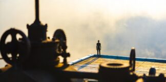 Cinematic shot of a solitary figure on a rooftop with ominous industrial foreground representing Final Destination Bloodlines and the viral horror franchise's record-breaking 2026 return to theaters