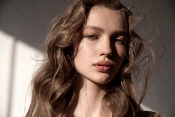 Ghost Layers 2026 Natural Hair Trend Model with natural textured hair featuring invisible ghost layers and soft, effortless movement in a beauty editorial setting.