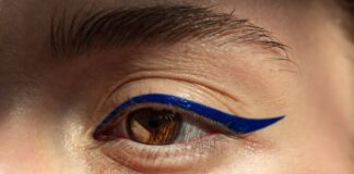 Graphic Liner: From Runway to Real Life Model with bold graphic liner eye look — floating cobalt line above the crease — representing Runway Magazine's complete guide to graphic liner from runway to real life