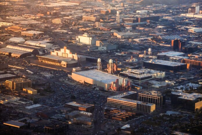 The Warner Bros Merger 2026 — Paramount Skydance Acquires WBD for $110 Billion Aerial view of Hollywood studio backlot at golden hour representing the Warner Bros merger and Paramount Skydance $110 billion acquisition reshaping entertainment industry power in 2026