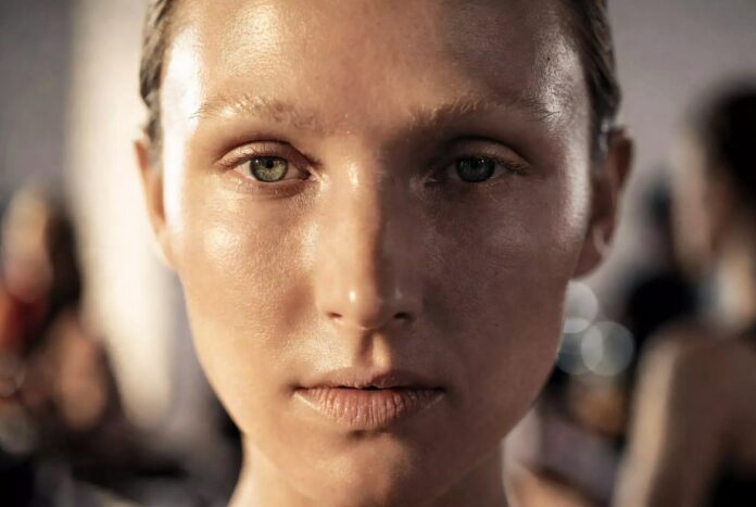 Model with luminous no-makeup makeup look showing natural skin texture and barely there coverage, representing Runway Magazine's guide to the no-makeup makeup look's runway origins and step-by-step recreation