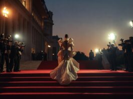 Red Carpet & Events Hub: Every Major Ceremony, Gala & Award Show A figure in a sculptural designer gown arrives on the red carpet at a major award show ceremony, representing Runway Magazine's complete red carpet fashion hub