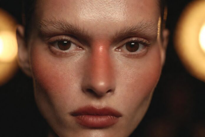 Runway Makeup Trends 2026: The Looks Defining the Season — Runway Magazine Model with runway makeup trends 2026 showing flushed skin and blurred lip representing Runway Magazine's complete breakdown of the season's five defining beauty directions