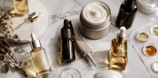 Haircare Reviews Are Officially Overtaking Makeup in the Beauty Industry Premium scalp care and biotech haircare products arranged on marble surface in editorial flat lay