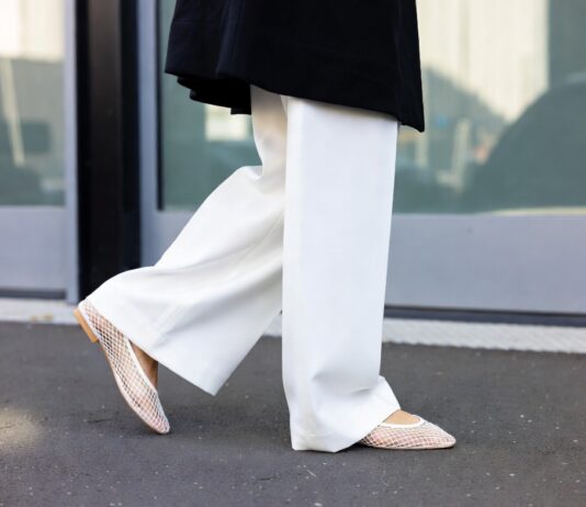 Barefoot Luxury Trend Takes Over Fashion Week Street Style With Mesh Flats and Minimal Shoes A street style look pairing sheer minimalist mesh flats with oversized tailored trousers outside a fashion week show