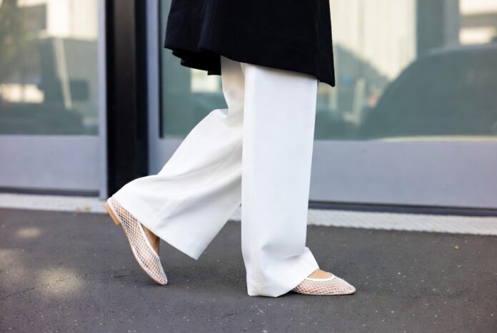 Barefoot Luxury Trend Mesh Flats and Minimal Shoes A street style look pairing sheer minimalist mesh flats with oversized tailored trousers outside a fashion week show