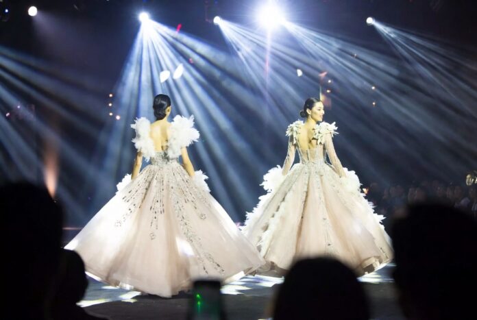 Model mid-stride in a dramatic feathered ball skirt on a Paris Fashion Week runway representing the breakout models 2026 season and the emergence of Awar Odhiang, Achol Ayor, and Stella Hanan as the next generation of luxury fashion stars