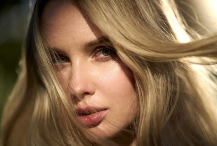Butter Blonde Hair Trend 2026 Warm Creamy Shade Model with glossy warm blonde hair in soft natural light showing a creamy, luminous finish.