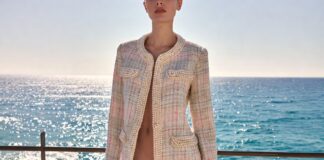 A model in a lightweight tweed look with pearls and nautical stripes on a sunny coastal terrace by the sea