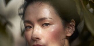 “Clean Girl Makeup” Is Evolving Into “Barely-There Skin” – The Minimal Beauty Trend Dominating 2026 Close-up of a woman with glowing dewy natural skin and barely-there makeup in soft diffused light.