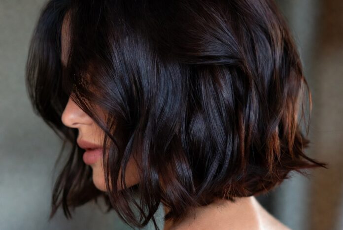 Espresso Brunette Long Bob Haircut — Summer 2026's Most Requested Celebrity Haircut Trend Woman with rich glossy dark espresso brunette long bob haircut representing the most requested celebrity haircut trend of summer 2026 evoking Katie Holmes hair and the luxury hair trends and glossy brunette hair aesthetic driving salon bookings in 2026