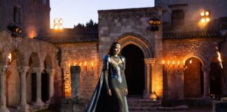 Why the Louis Vuitton Cruise 2026 Show in Avignon Is Defining Summer Luxury Fashion Models in armor-inspired metallic gowns on a stone runway inside a gothic medieval palace courtyard at dusk