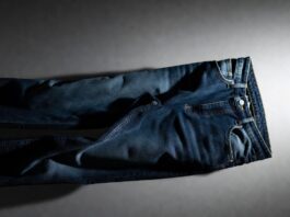 Luxury denim jeans in deep indigo displayed on a clean editorial backdrop with soft lighting.
