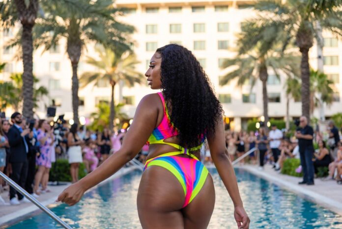 Confident figure in swirl-print one-piece swimsuit mid-stride on a Miami runway representing Megan Thee Stallion swimwear Hot Girl Summer Swimwear PARAISO Miami Swim Week 2026 runway show and viral fashion moment