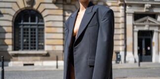 Micro Shorts and Oversized Tailoring Are Creating Fashion’s Most Debated Silhouette Fashion week attendee in ultra-short tailored shorts and oversized structured blazer on European pavement representing the micro shorts trend 2026 and the polarizing street style silhouette debate in luxury fashion