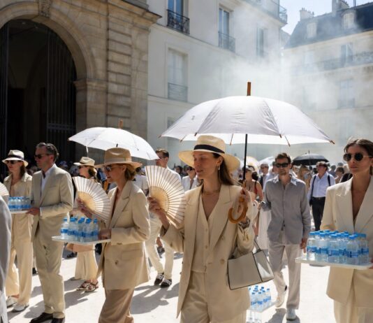 Paris Fashion Week Heatwave Forces Luxury Runway Rethink Elegant fashion week guests shielding from intense Paris heat outside a luxury runway venue