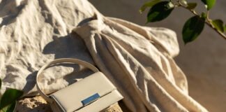 A luxury handbag and garment made from recycled and upcycled materials displayed in soft, elegant natural light