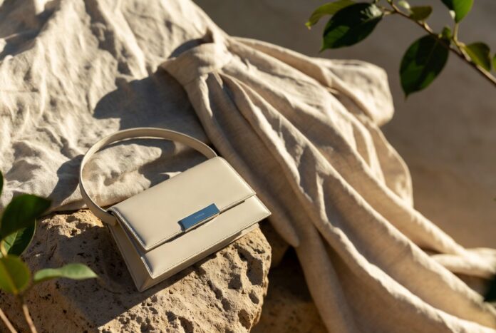 Prada Miu Miu Sustainable Luxury Fashion 2026 A luxury handbag and garment made from recycled and upcycled materials displayed in soft, elegant natural light