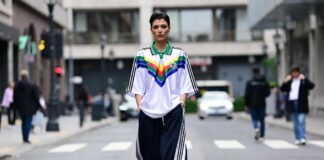Retro Sportswear Is Taking Over Fashion Week Streets – Soccer Jerseys and Track Pants Go Luxury Fashion week attendee in a vintage soccer jersey and wide-leg track pants walking on a city street.