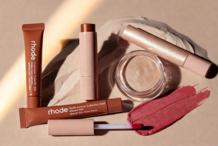 Rhode's Summer 2026 Collection — Pocket Bronze, Highlight Milk, and the Glazed Skin Trend Moment Rhode Summer Collection 2026 product flatlay featuring Pocket Bronze cream bronzer stick and Highlight Milk hybrid luminizer representing the Hailey Bieber Rhode glazed skin trend viral beauty products summer makeup trends and beauty launches 2026 Rhode beauty launch moment.