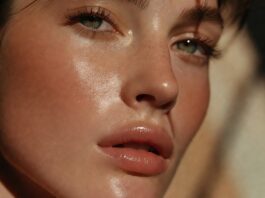 A fresh, glowy summer makeup look with skin tint, cream blush, and glossy lips on radiant, lightly bronzed skin