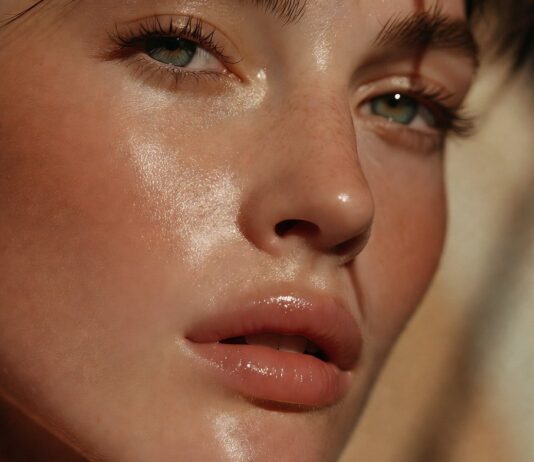 A fresh, glowy summer makeup look with skin tint, cream blush, and glossy lips on radiant, lightly bronzed skin