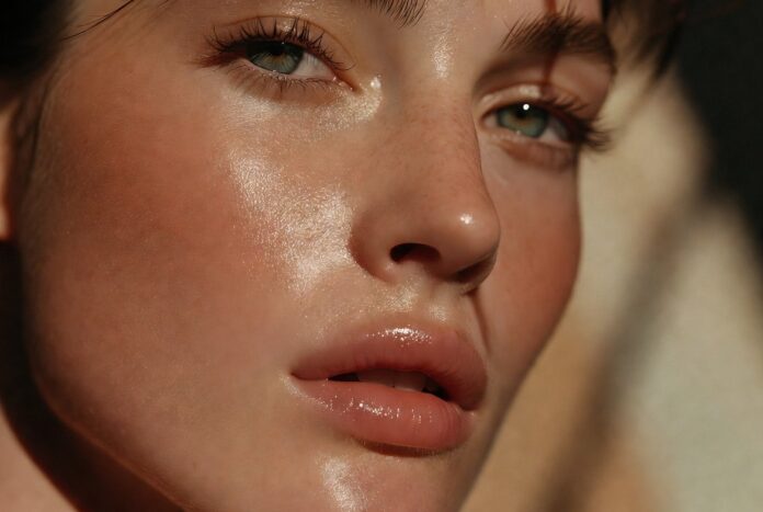 Summer Makeup Tips 2026 Lightweight Glowy Look A fresh, glowy summer makeup look with skin tint, cream blush, and glossy lips on radiant, lightly bronzed skin