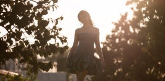 A model in a sculptural bubble-hem dress with dramatic volume styled minimally on a summer runway