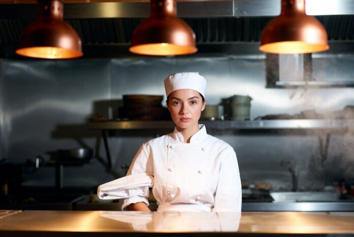 The Bear Season 5 Television Era Young female chef in a warm restaurant kitchen reflecting the emotional force of prestige television