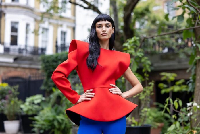 dwoa Aboah and Topshop SS26 'Le Jardin' — The Campaign That Confirms Fashion's Most Consequential British Model Bold sculptural fashion editorial image evoking the Topshop SS26 Le Jardin campaign fronted by Adwoa Aboah featuring statement silhouettes in vivid red and electric blue representing British fashion icon Topshop comeback 2026 and fashion campaign authority