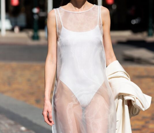 Model in a sheer fashion trend look wearing organza over a fitted bodysuit on a summer street representing Runway Magazine's complete guide to the sheer layering trend of 2026