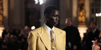 Butter-yellow couture suit with surrealist jewelry and black cowboy boots at a Paris show