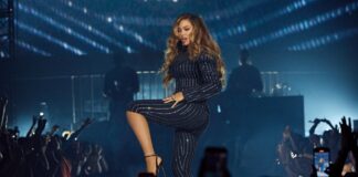 Beyoncé Capri Suit Signals a Sharp New Stage-Tailoring Era Beyoncé’ Crystal pinstripe capri suit with sculpted shoulders and black pumps under dramatic stadium lighting