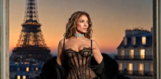 Sheer black lace corset gown with a fringed skirt, diamond choker, and black fur stole styled for a Paris evening
