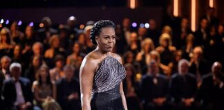 Michelle Obama Essence Fest Gown Signals a New Fashion Era Elegant black fringed evening gown on a cultural festival stage with warm editorial lighting