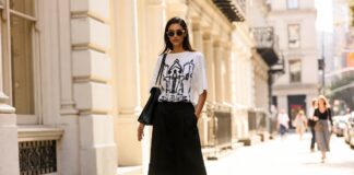Oversized T-Shirts End the Baby Tee Era for Summer 2026 Oversized graphic T-shirt paired with tailored Bermuda shorts and slim sandals for an easy summer silhouette